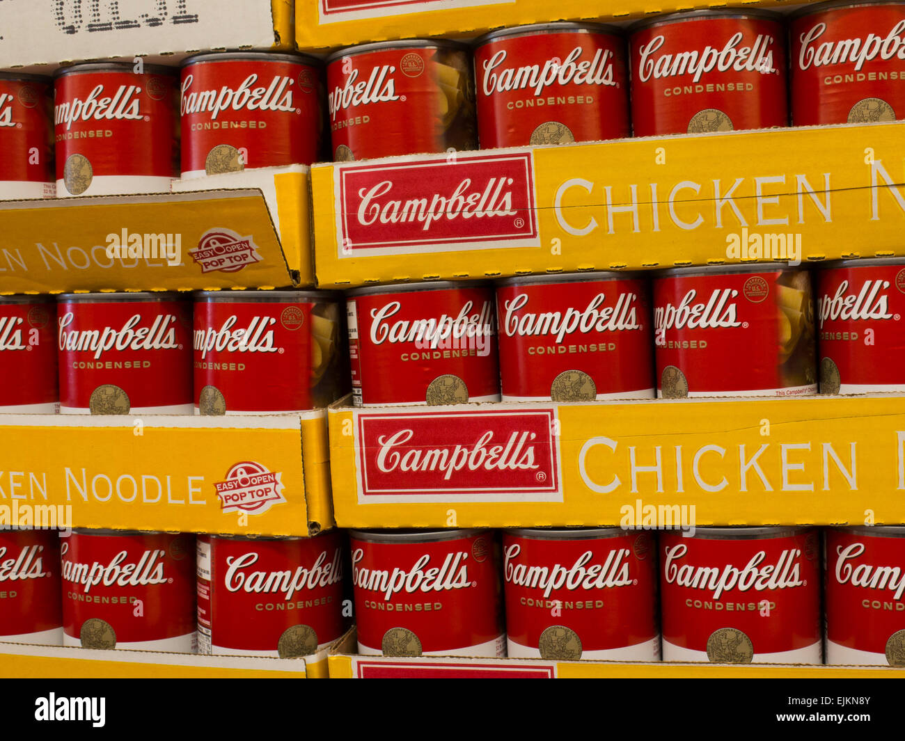 Cans of Campbell's chicken noodle soup are stacked in warehouse style supermarket. Stock Photo