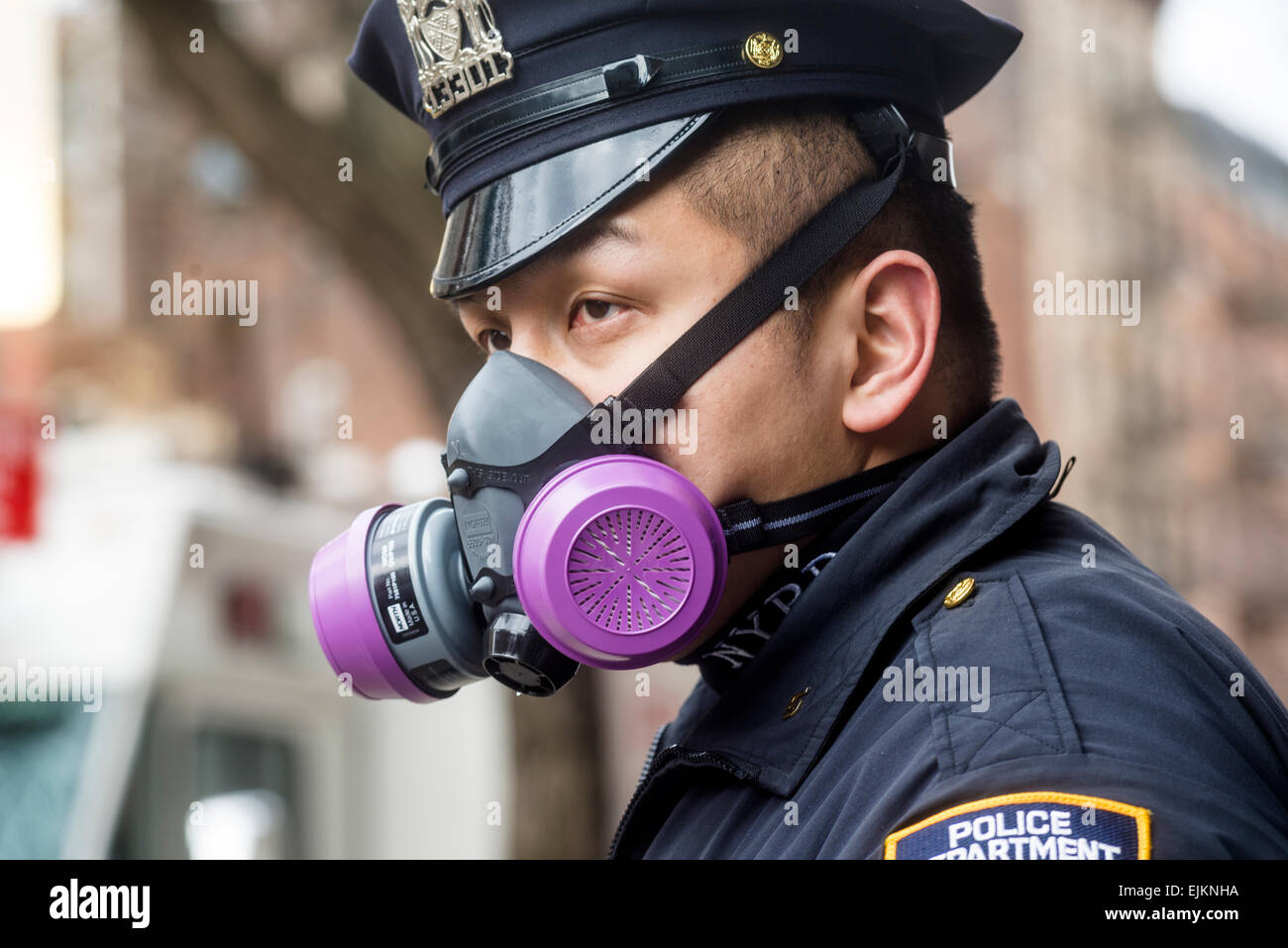 New NY - 28 March 2014 Asian police officer wearing a gas mask the recovery of the 26 March gas explosion on Second Avenue and East 7th Street in the