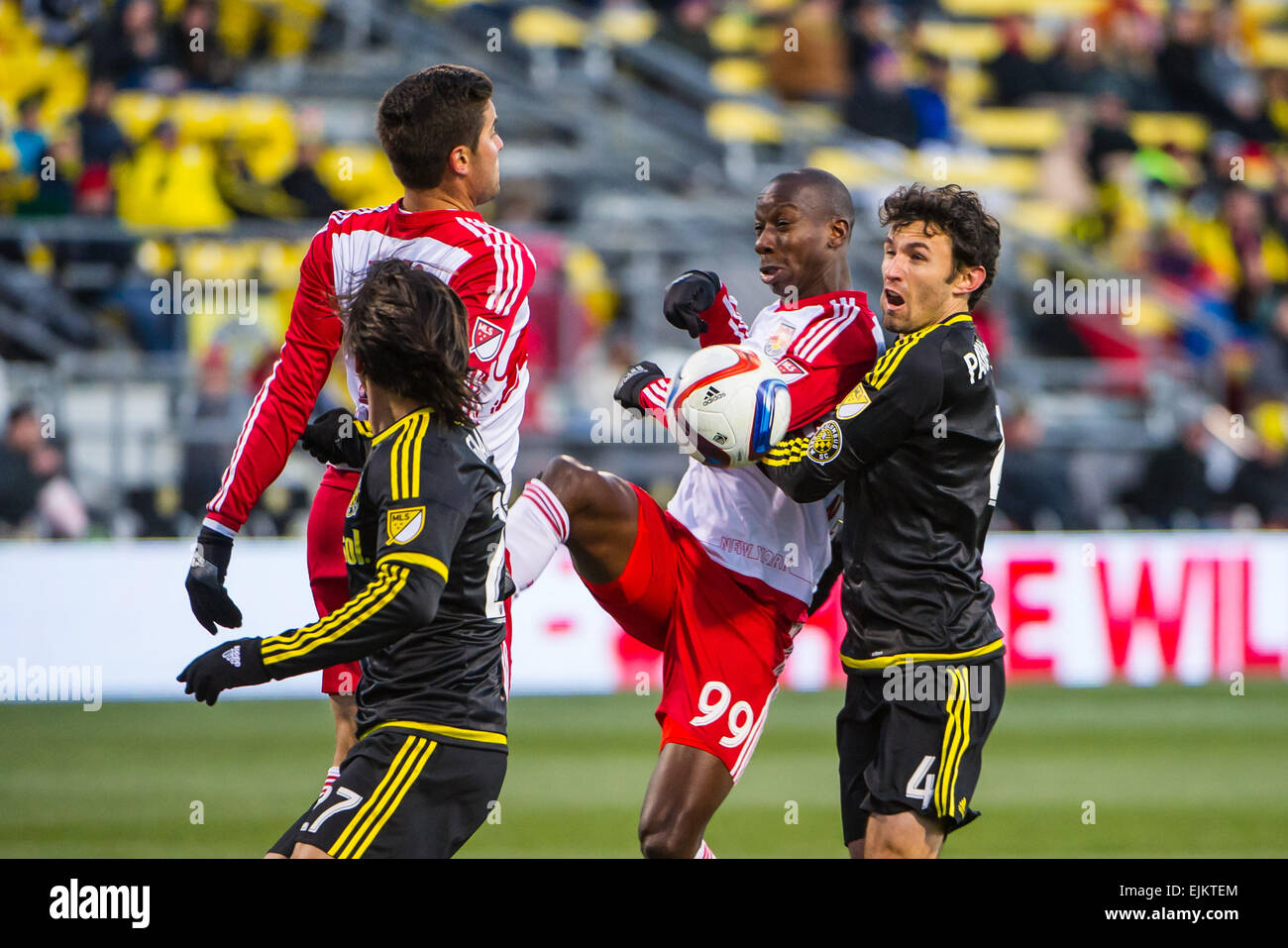 In the first half, Columbus Crew SC defender Michael Parkhurst (4) and New York Red Bulls forward Bradley Wright-Phillips (99) battle for the ball during the match between New York Red Bulls (1-0-1, 4 points) and Columbus Crew SC (1-1-0, 3 points) at MAPFRE Stadium, in Columbus OH. on March 28, 2015. Stock Photo