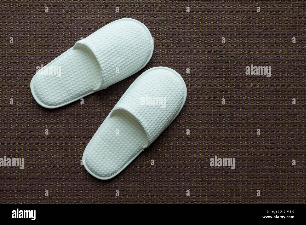 White slippers on brown carpet Stock Photo