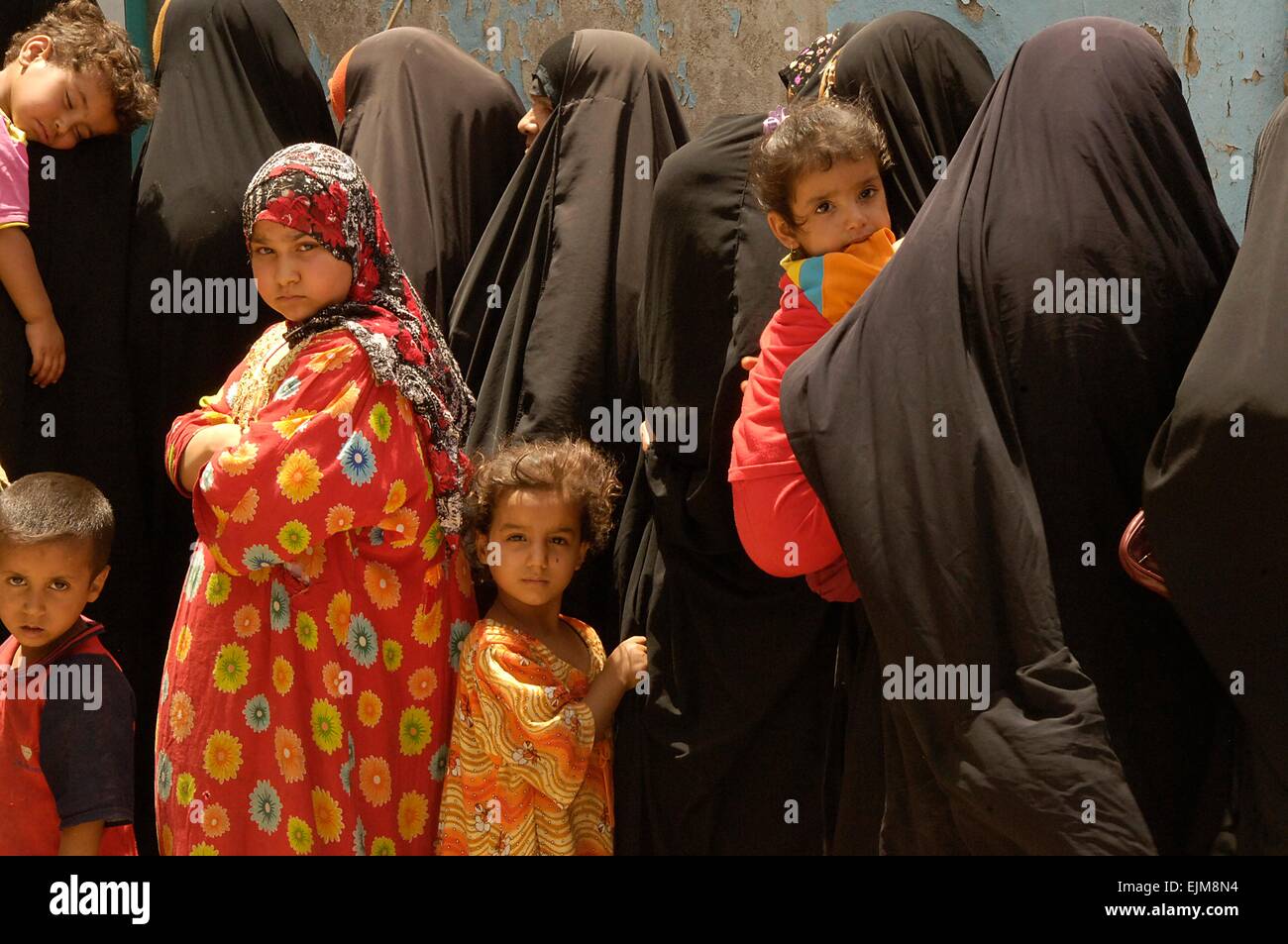 Iraqi women and children wait in line for medical care during a humanitarian aid and medical operation at Al-Nasser Police Station June 5, 2008 February 22, 2007 in Sadr City, Iraq. Stock Photo