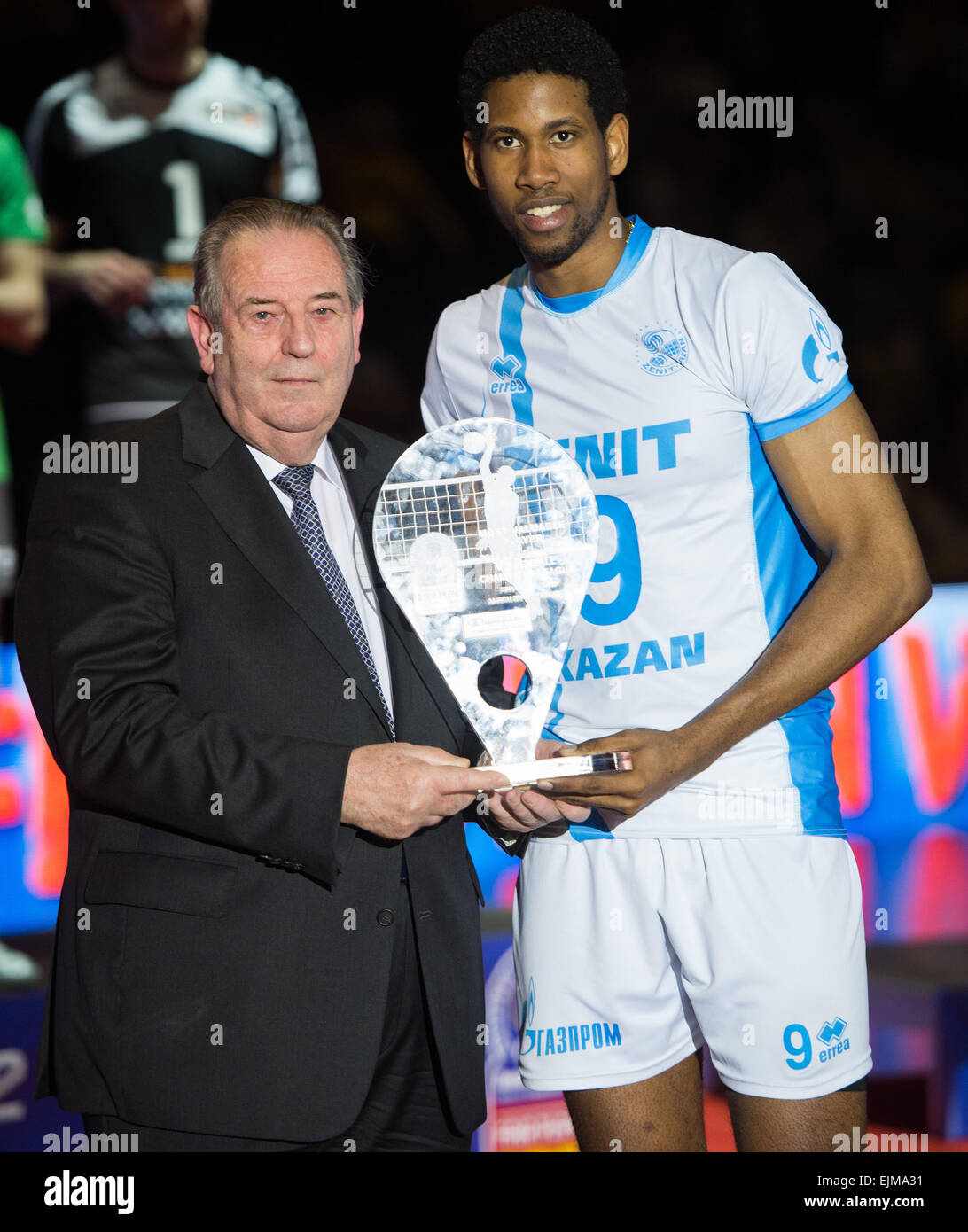 Berlin, Germany. 29th Mar, 2015. Andre Meyer (L), president of the European Volleyball Confederation CEV, hands the MVP trophy to Zenit Kazan's Wilfredo Leon Venero during the victory ceremony after the Volleyball Champions League Final Four match at Max Schmeling Hall in Berlin, Germany, 29 March 2015. Photo: LUKAS SCHULZE/dpa/Alamy Live News Stock Photo