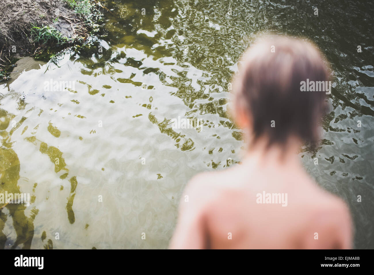 Little boy near water at the beach on hot summer day. Having fun during vacation. Stock Photo