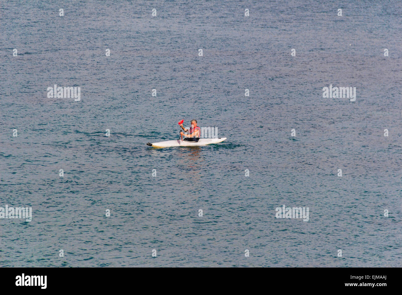 Single person kayaking at Cardigan Bay at Criccieth, North Wales, United Kingdom. Stock Photo