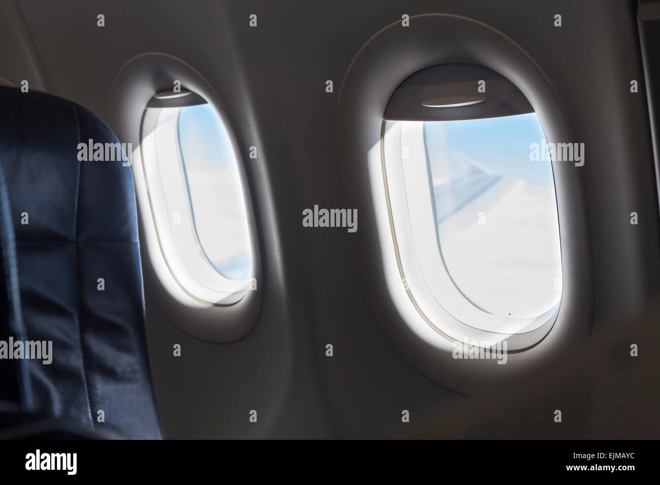 Detail of seat and windows inside an aircraft. Stock Photo