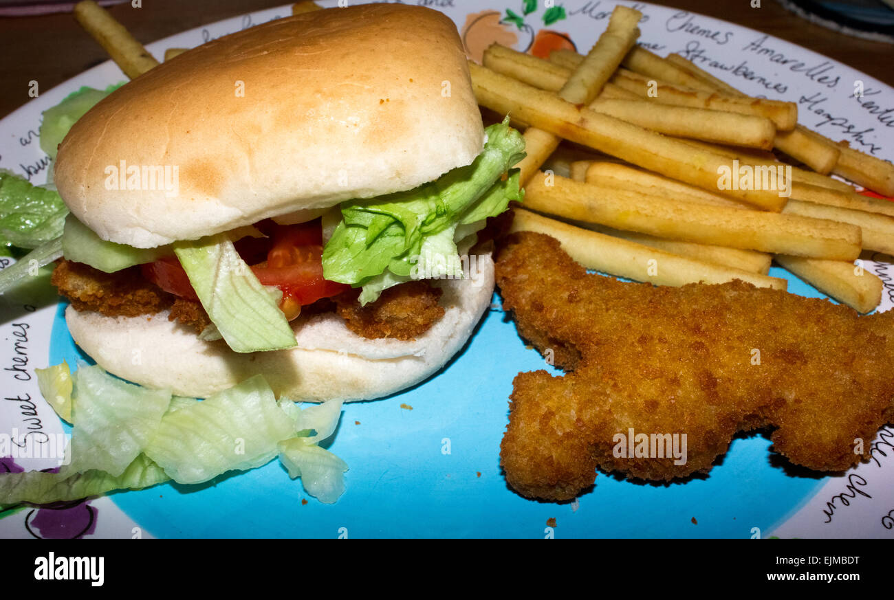 Turkey dinosaurs in a bun with salad, tomatoes, cucumber and fries on