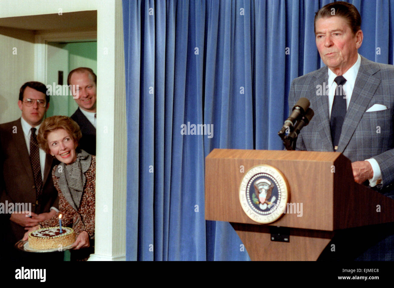 US President Ronald Reagan during a press conference in the Briefing Room of the White House as First Lady Nancy Reagan and David Gergen prepare a surprise Birthday Party in honor of President 71st birthday February 4, 1983 in Washington, DC. Stock Photo