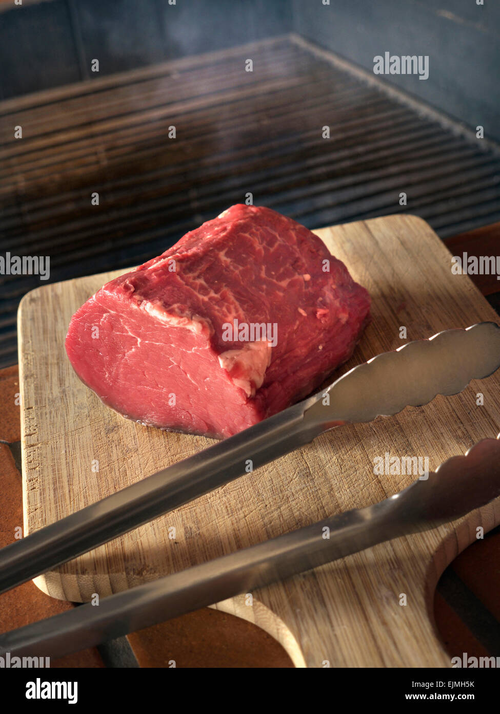 Filet Tenderloin of beef with outdoor kitchen barbeque behind Stock Photo
