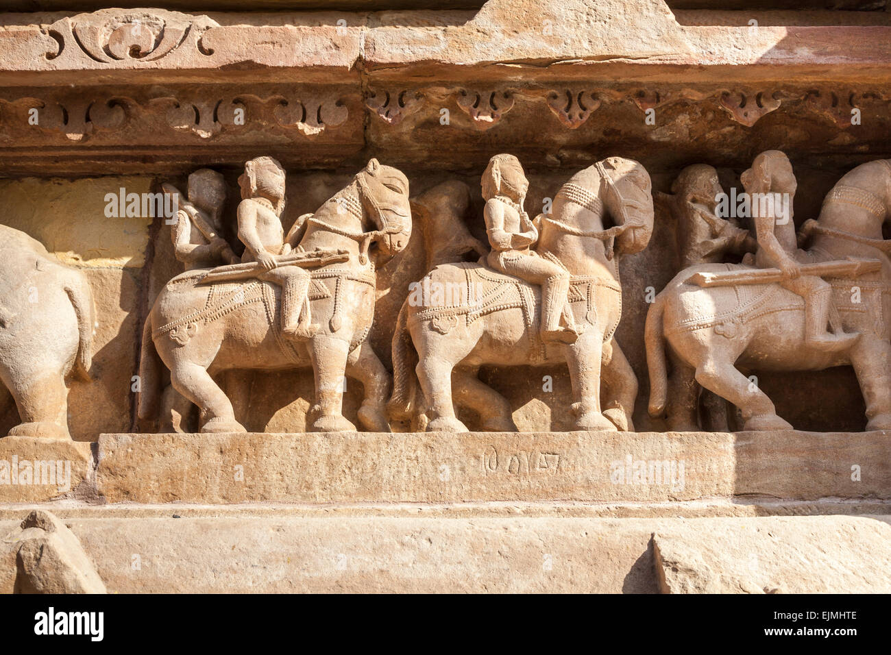Carvings at a Hindu temple in the Western Group at Khajuraho, Madhya Pradesh, India depicting mounted warriors on horseback Stock Photo