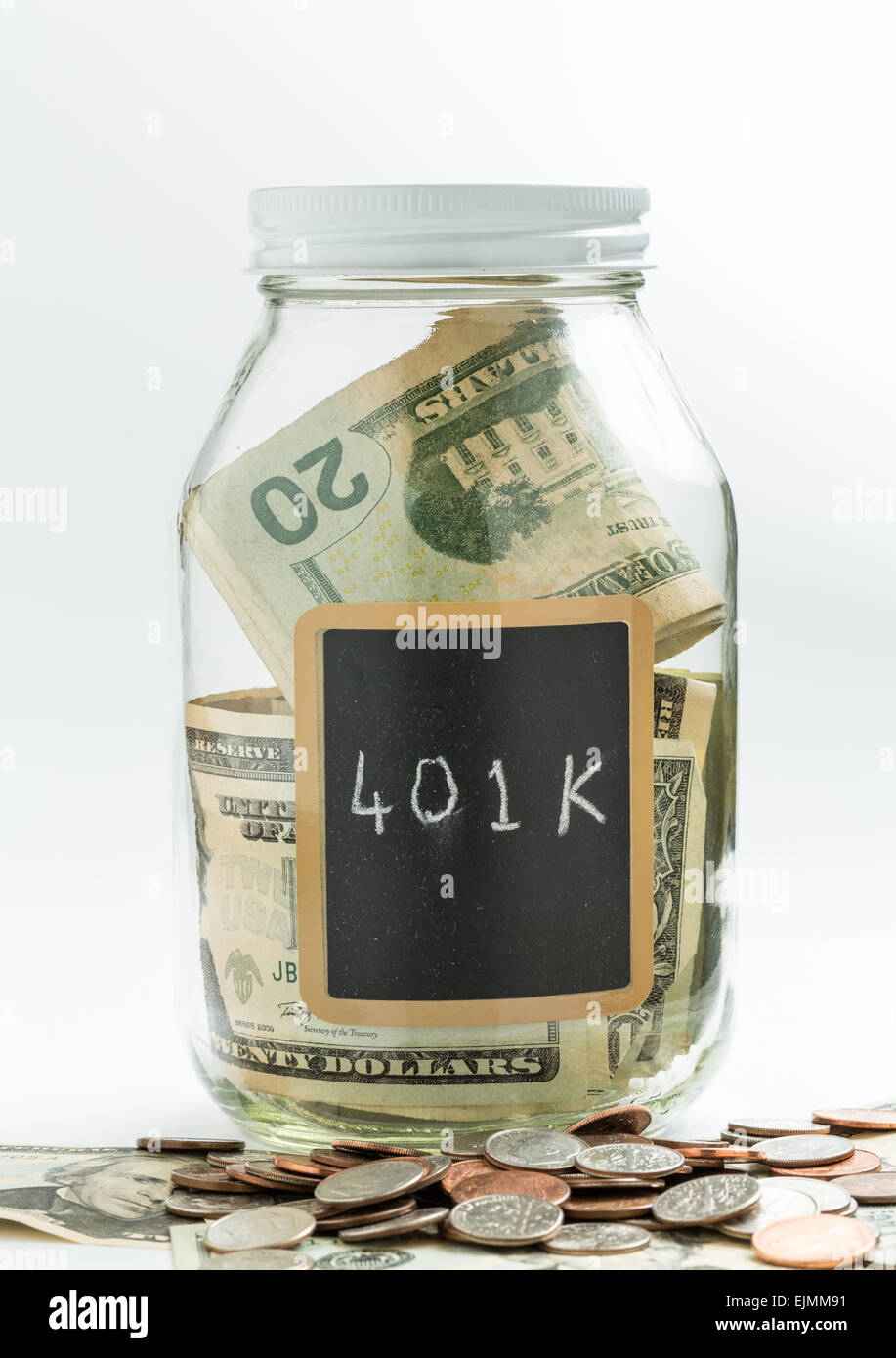 Glass jar on white background with black chalk label or panel and used for saving of US dollar bills for 401K retirement savings Stock Photo