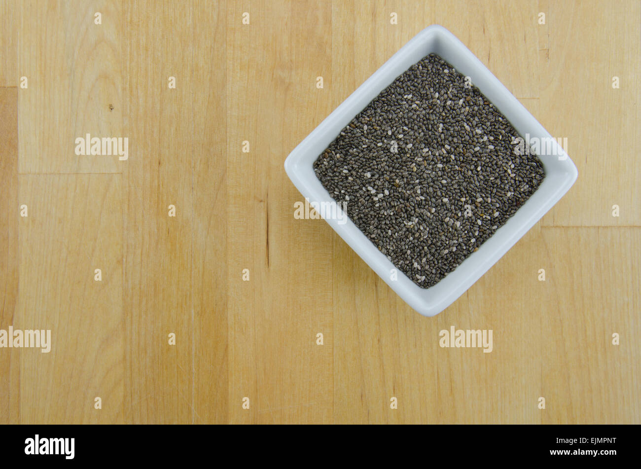 A white ceramic bowl holds the super food of chia seeds Stock Photo