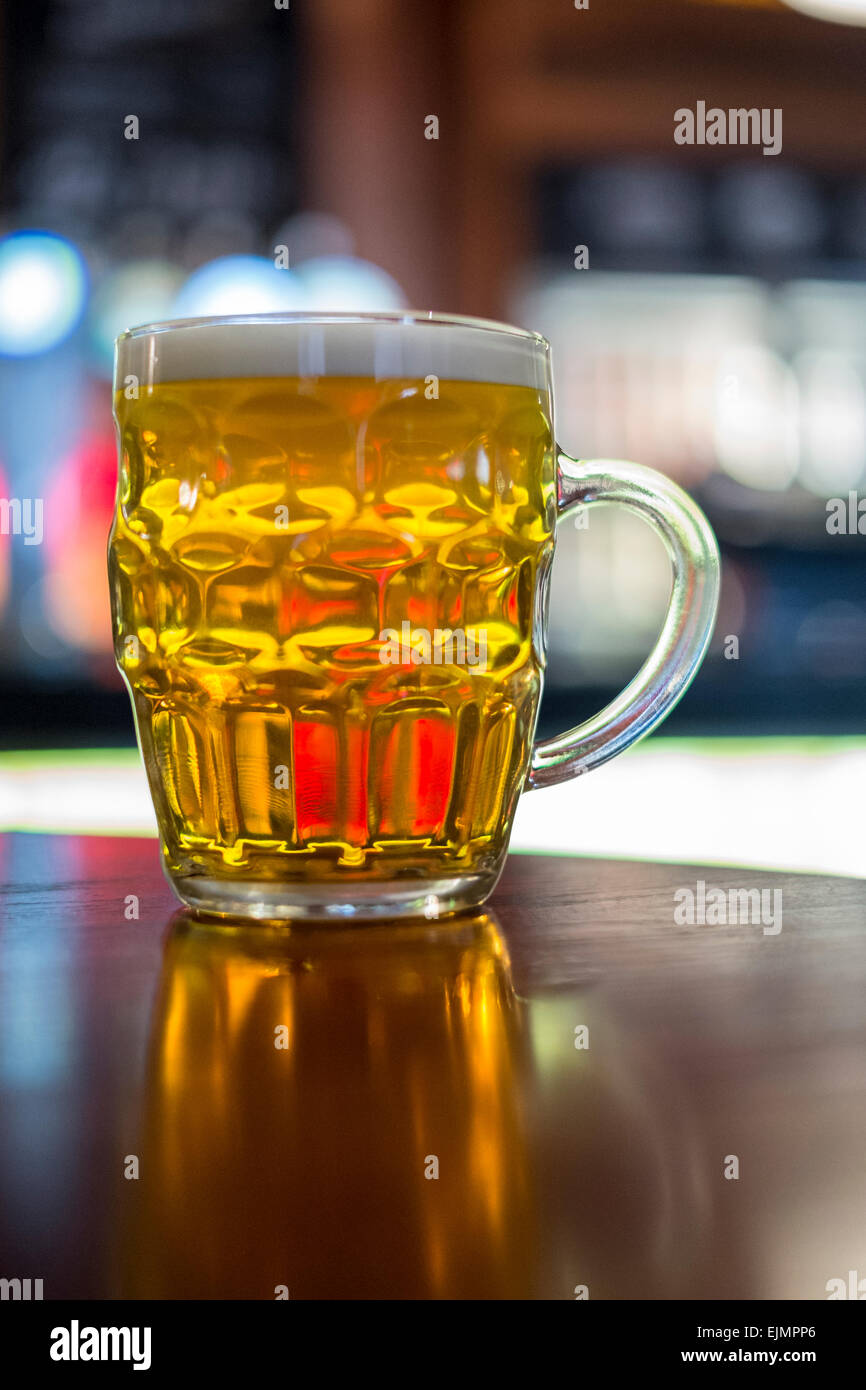 light coloured beer in a dimpled glass often called a glass with a handle Stock Photo
