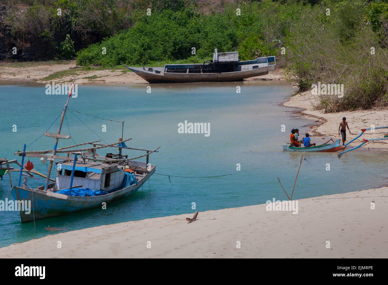 A sandy beach and fishing boats on a lagoon-like seascape in the fishing beach of Pero in Pero Batang villlage, Kodi, Southwest Sumba, Indonesia. Stock Photo