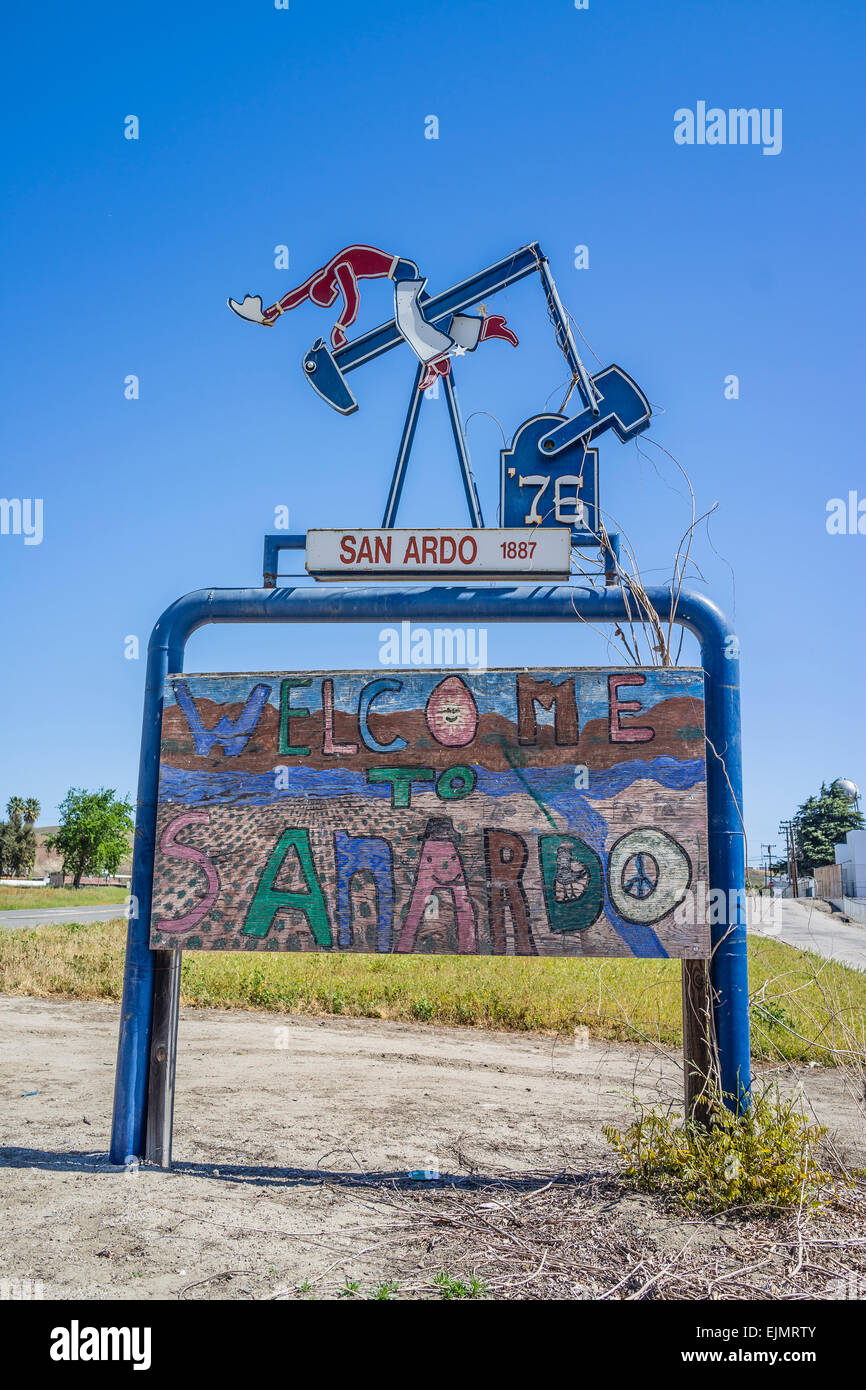 The to San Ardo sign featuring a sculpture of a oil drilling