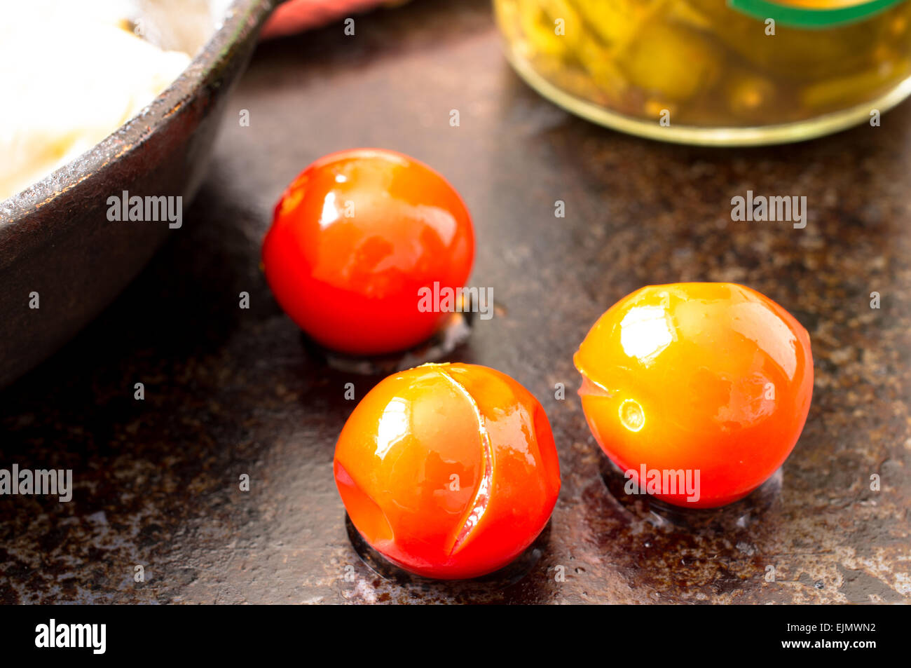 Three pickled, marinated cherry tomatoes on the table Stock Photo