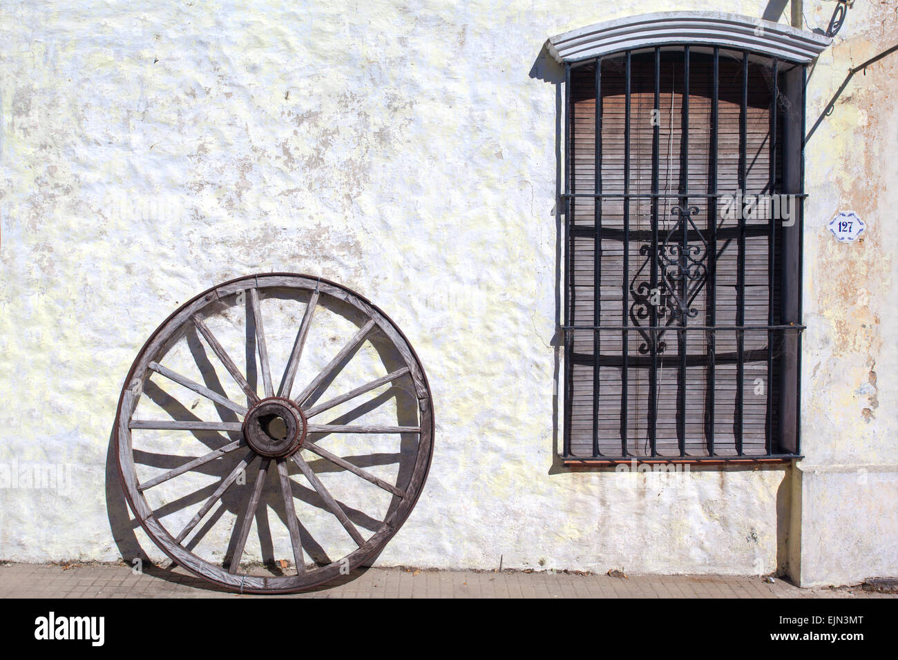 Old wood wheel & window. Colonia del Sacramento, Uruguay. Stock Photo