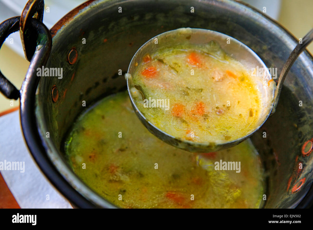 Pigiron saucepan with vegetable soup and a scoop Stock Photo Alamy