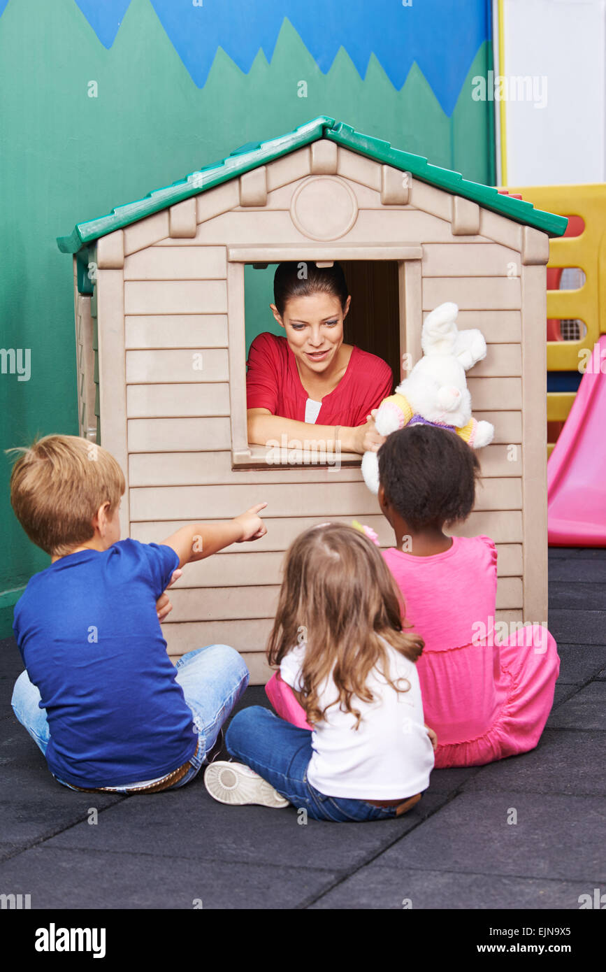 Nursery teacher using playhouse for theater play with stuffed animals for children Stock Photo