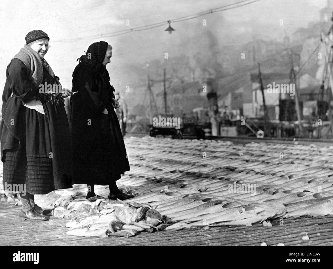 Two women, the shrewdest judges in the market were discussing propects when this pictures was taken after the landing of the Easter catches on the Fish Quay at North Shields Stock Photo