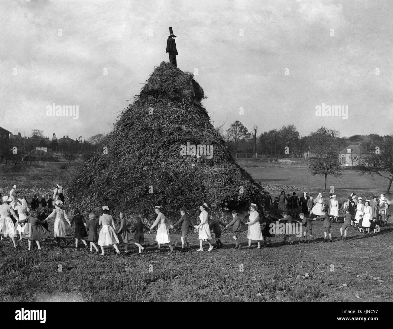 One of the biggest bonfires to be burnt is the huge 50 ft. high pyre erected in to ground of the Aldersbrook Children’s Homes, Wanstead, London. This pyre took a month to build and is the remnants of all the waste branches and rubbish that local firms and people wish to dispose of. These children, toddlers, and those up to the age of 15, watch this huge nobfire burn and are given a display of fireworks bought from donations and collections from well wishers. The toddlers are not told about Guy Fawkes because many of them are very upset when they see him burning. They are told it is a bag of st Stock Photo