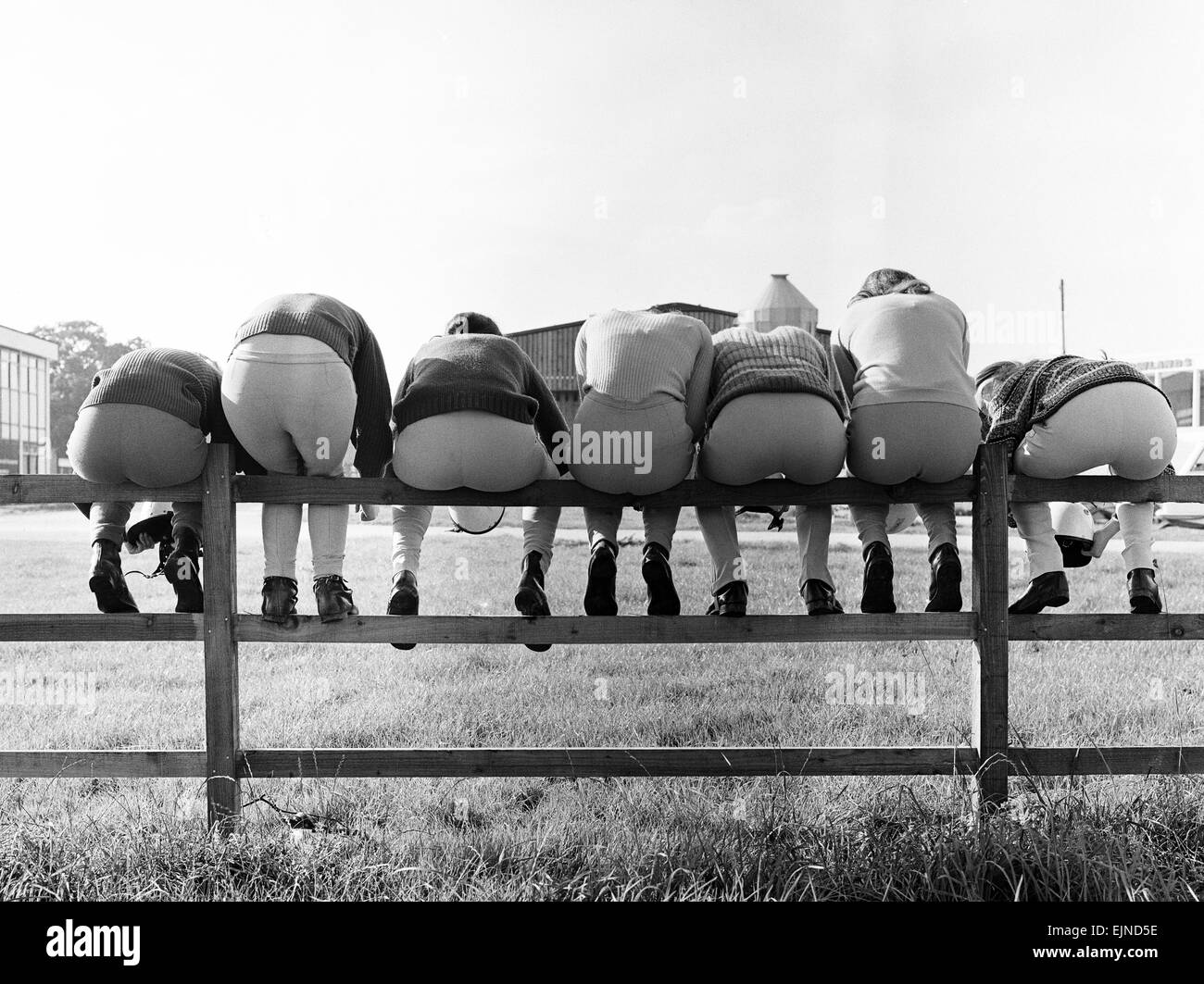 Seven young apprentice female jockeys sitting on a wooden fence during their training at the National Equestrian Centre in Stoneleigh, Warwickshire.The course runs for six weeks and those who make the grade can then apply for professional licences. 14th August 1974. Stock Photo