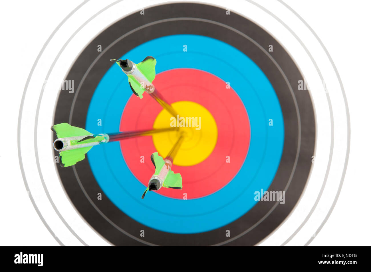 The bull's eye of an archery target hit by three arrows in short dept