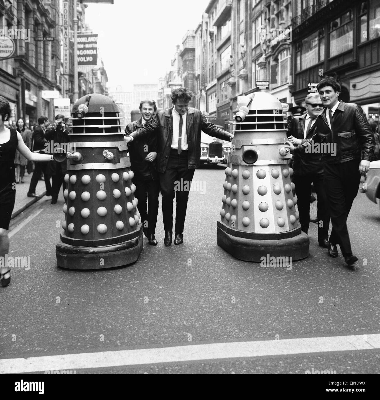 The Daleks come to Bond Street, London. A new pop group calling themselves the ' Go Goes' seen here in London's West End shortly before recording their new song, ' I'm Gonna have a Dalek for Christmas' The group pose with two of the alien robots from the TV show Dr Who. 25th November 1964 Stock Photo
