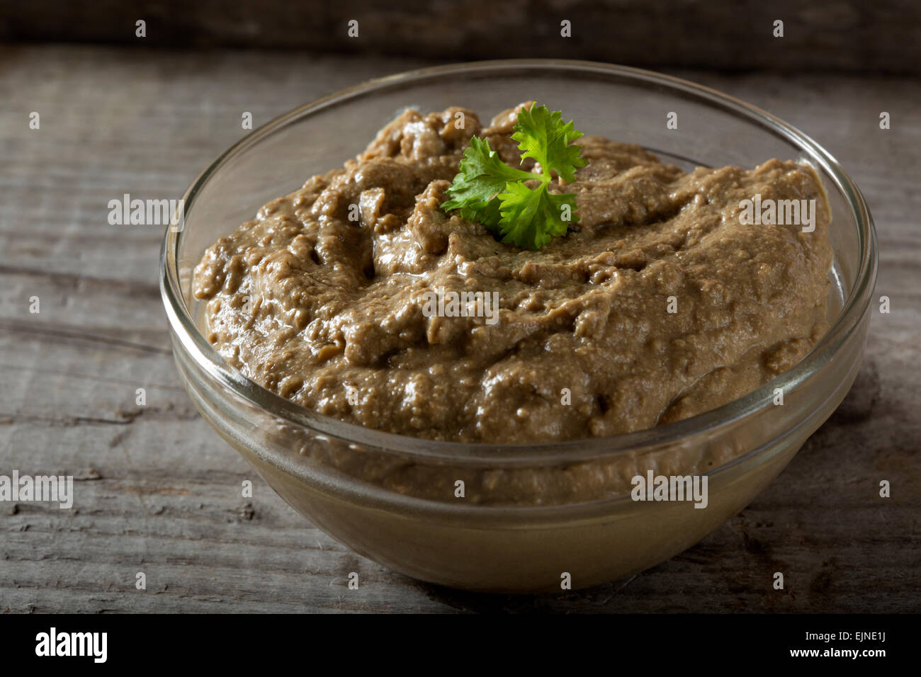 Bowl of liver pate over wooden background Stock Photo