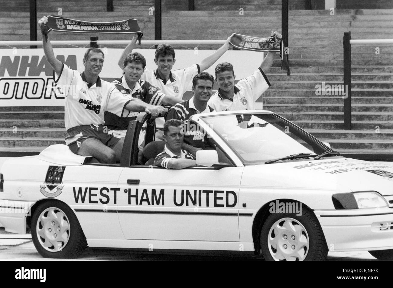 West Ham footballer Julian Dicks takes the driving seat as the West Ham team announce Dagenham Motors as their new kit sponsors. Left to right behind Julian are: Alvin Martin, Clive Allen, Tony Gale, Steve Potts and Stuart Slater. 7th August 1992. Stock Photo