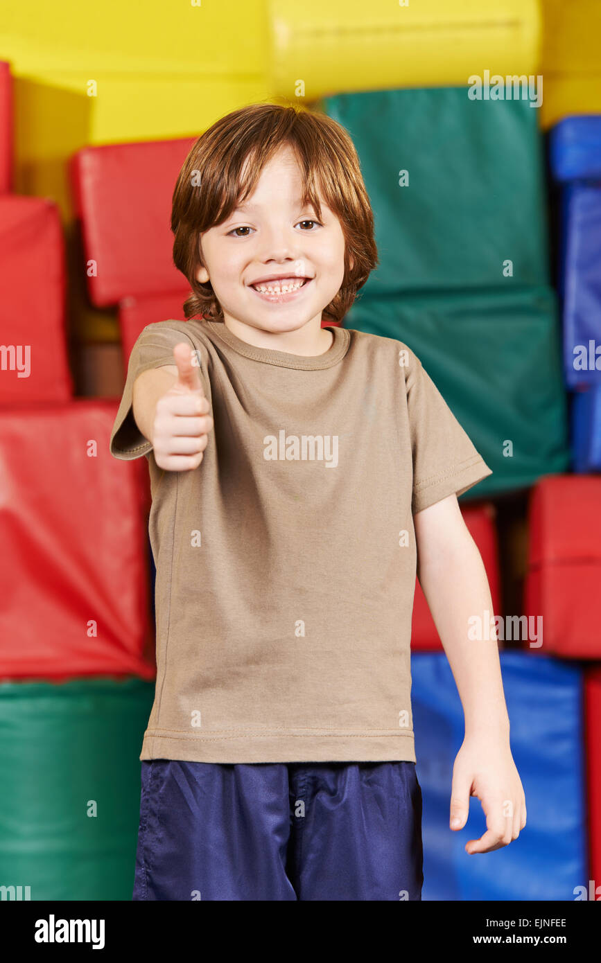 Happy boy holding thumbs up in gym of kindergarten Stock Photo