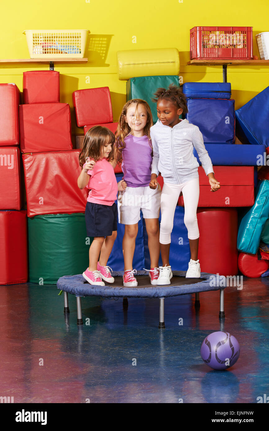 Three children jumping on trampoline together in gym of a kindergarten  Stock Photo - Alamy