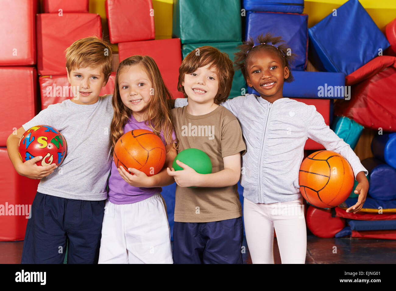 Happy children as team with different balls in a gym of a preschool ...