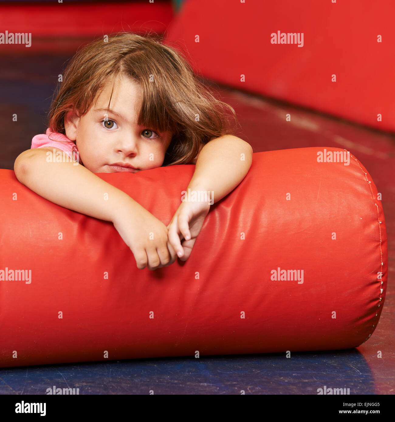 Girl laying on pillow for relaxation in a gym in kindergarten Stock Photo