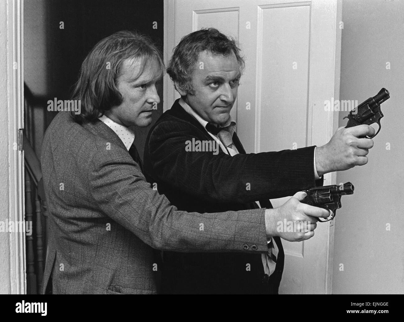 Detective Sergeant George Carter (left played by Dennis Waterman) and Detective Inspector John 'Jack' Regan (right played by John Thaw) seen here during rehearsals before a take on the set of the Euston Films TV series The Sweeney. The series focuses on the Flying Squad, a branch of the Metropolitan Police tasked with tackling armed robbery and violent crime in London. The programme's title derives from Sweeney Todd, which is Cockney rhyming slang for 'Flying Squad'. 8th December 1975 *** Local Caption *** Planman - - 02/07/2010 - - Stock Photo
