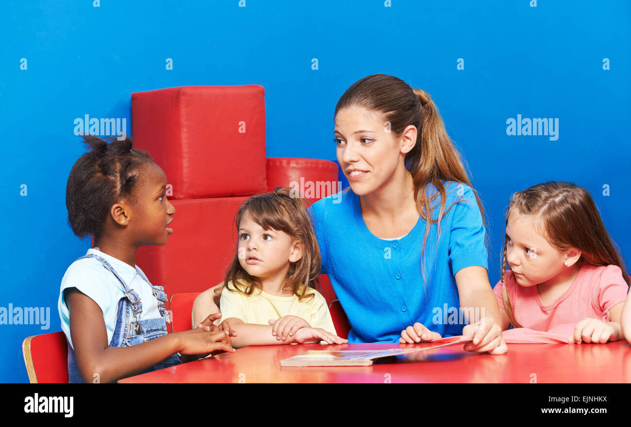 Children talking during language promotion in kindergarten with speech therapist Stock Photo