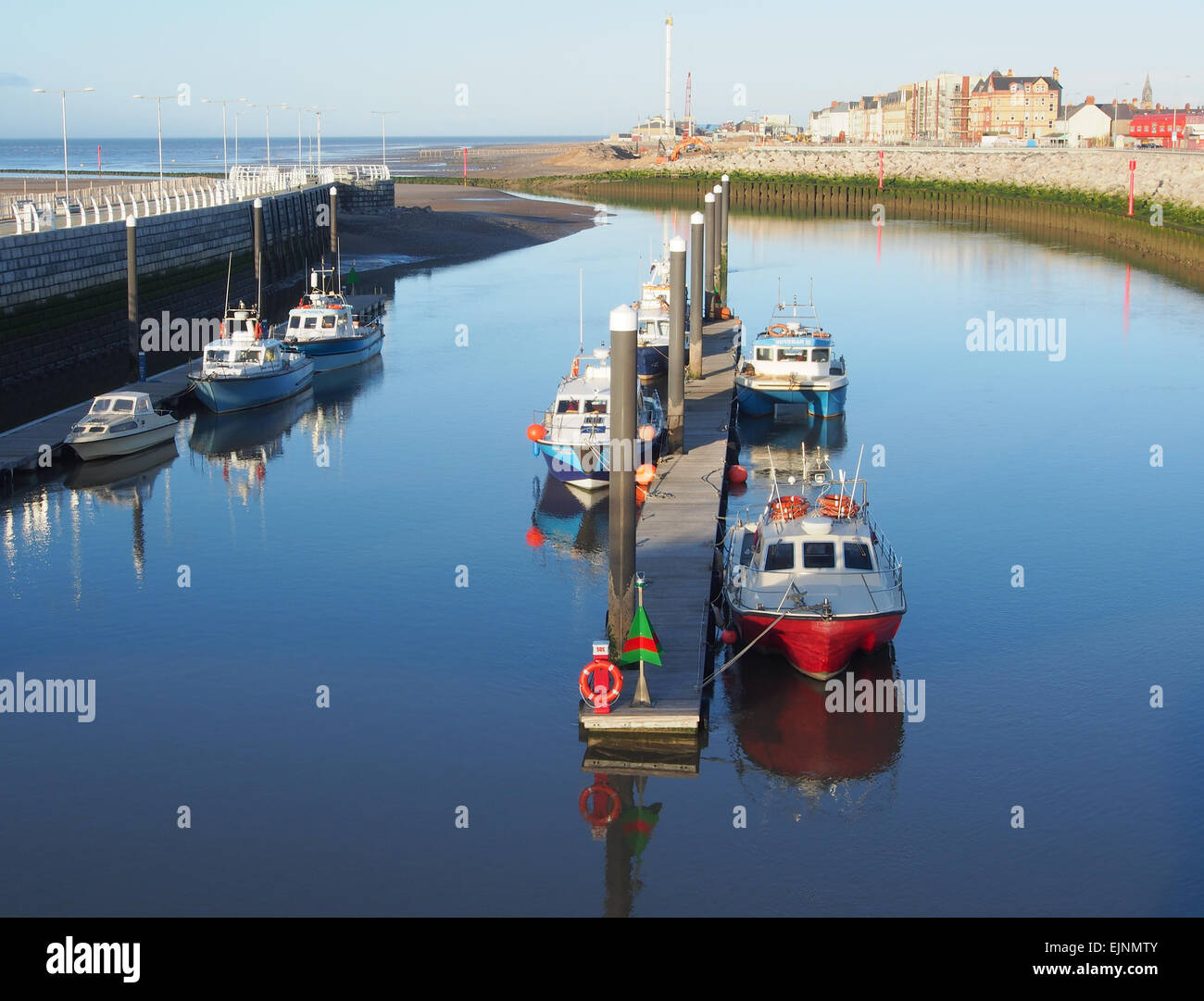 Boats moored at the marina in Kimnel Bay, Rhyl in Wales taken from the Dragon Bridge with Rhyl in the background. Stock Photo