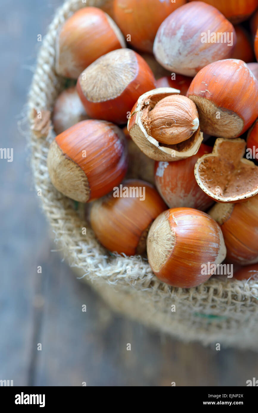 Filbert nut in burlap sack on wooden background Stock Photo