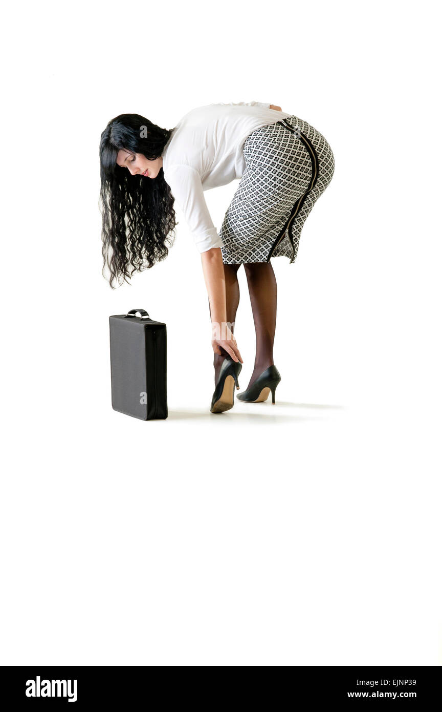 Young business woman adjusting her high heel shoe Stock Photo