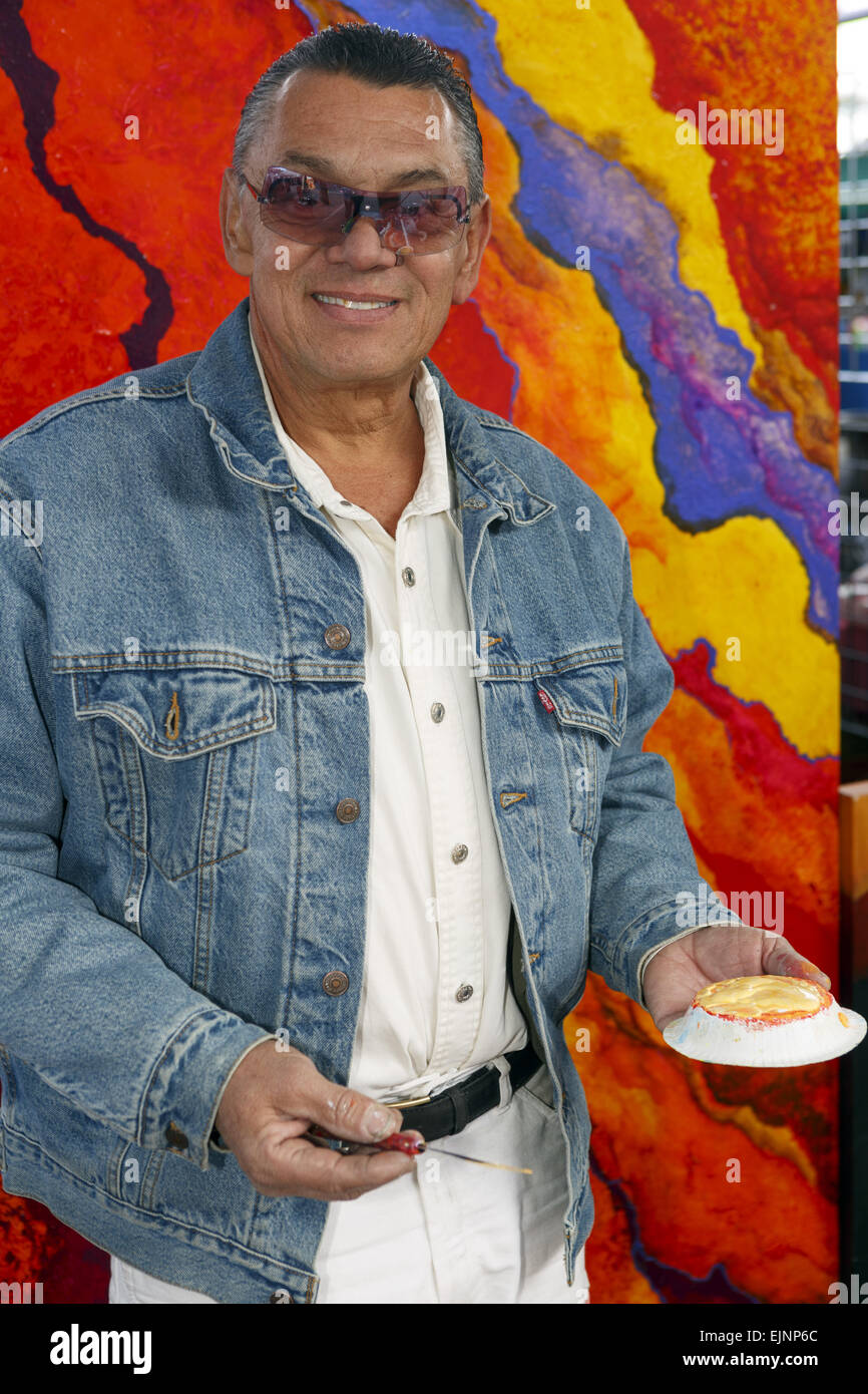 Artist holding palette knife and oil paint smiling Stock Photo - Alamy