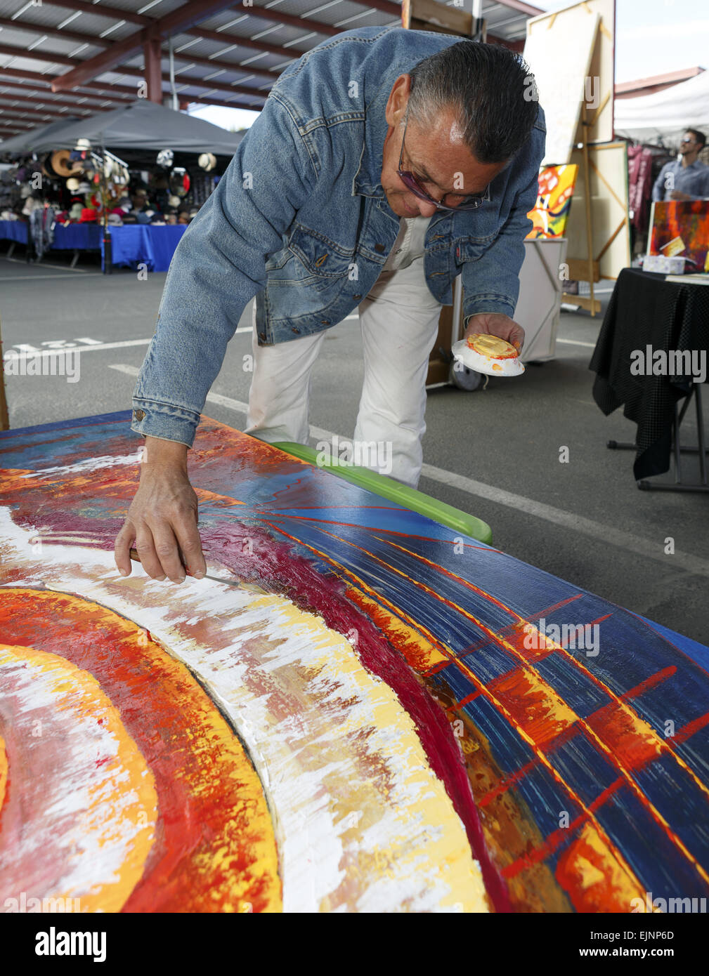 Artist laying oil paint on to canvas at College of the Desert Weekend Street Fair Palm Desert Coachella Valley Riverside County California USA Stock Photo