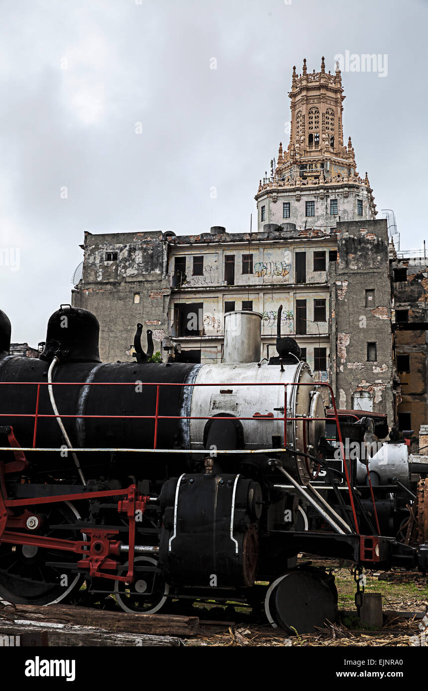 Old American steam engine being restored and renovated to former glory at a rail yard in Old Havana in Cuba with ruins behind Stock Photo