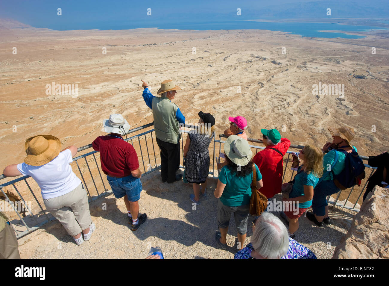 MASADA, ISRAEL - OCT 14, 2014: A guide gifts an explanation about Masada to tourists Stock Photo