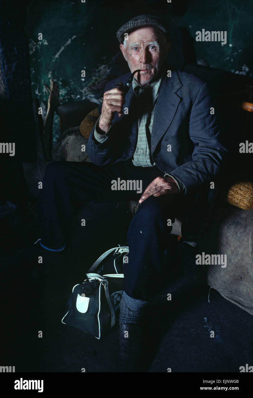 Blue Stack Mountains farmer inside cottage smoking pipe, Donegal, Ireland Stock Photo