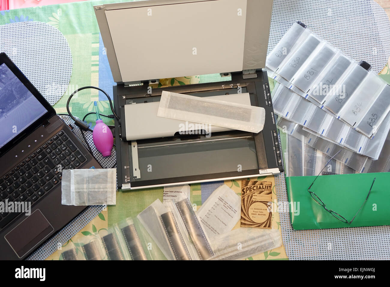 Laptop film scanner and negatives on a table being scanned and transfered to a computer for printing. Stock Photo