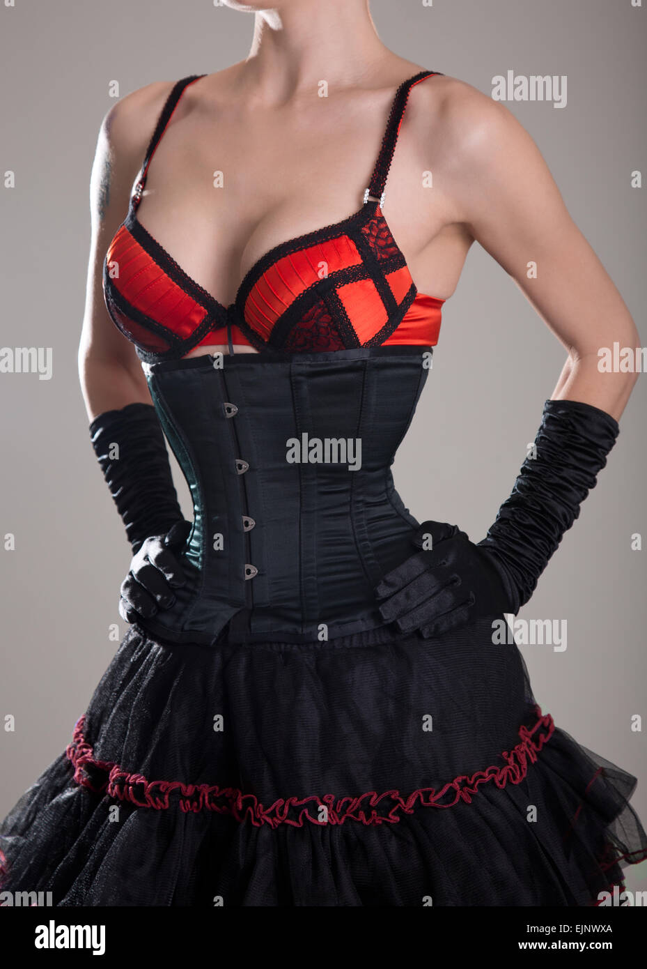 Sexy woman in black corset and red bra, studio shot on white background  Stock Photo - Alamy