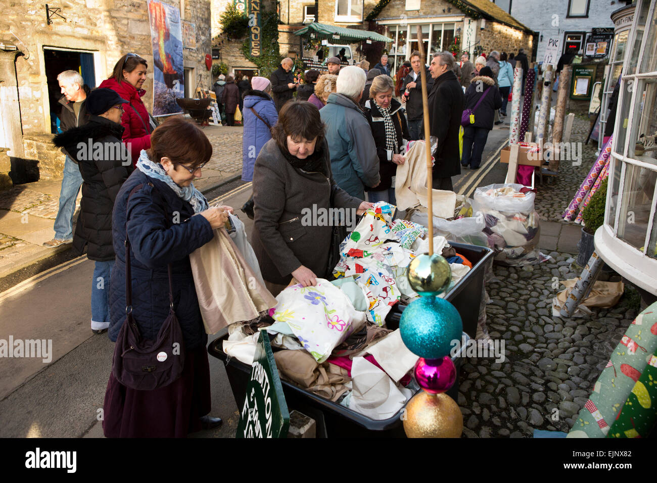 UK, England, Yorkshire, Grassington, Dickensian Festival, women rummaging for bargains at fents stall Stock Photo