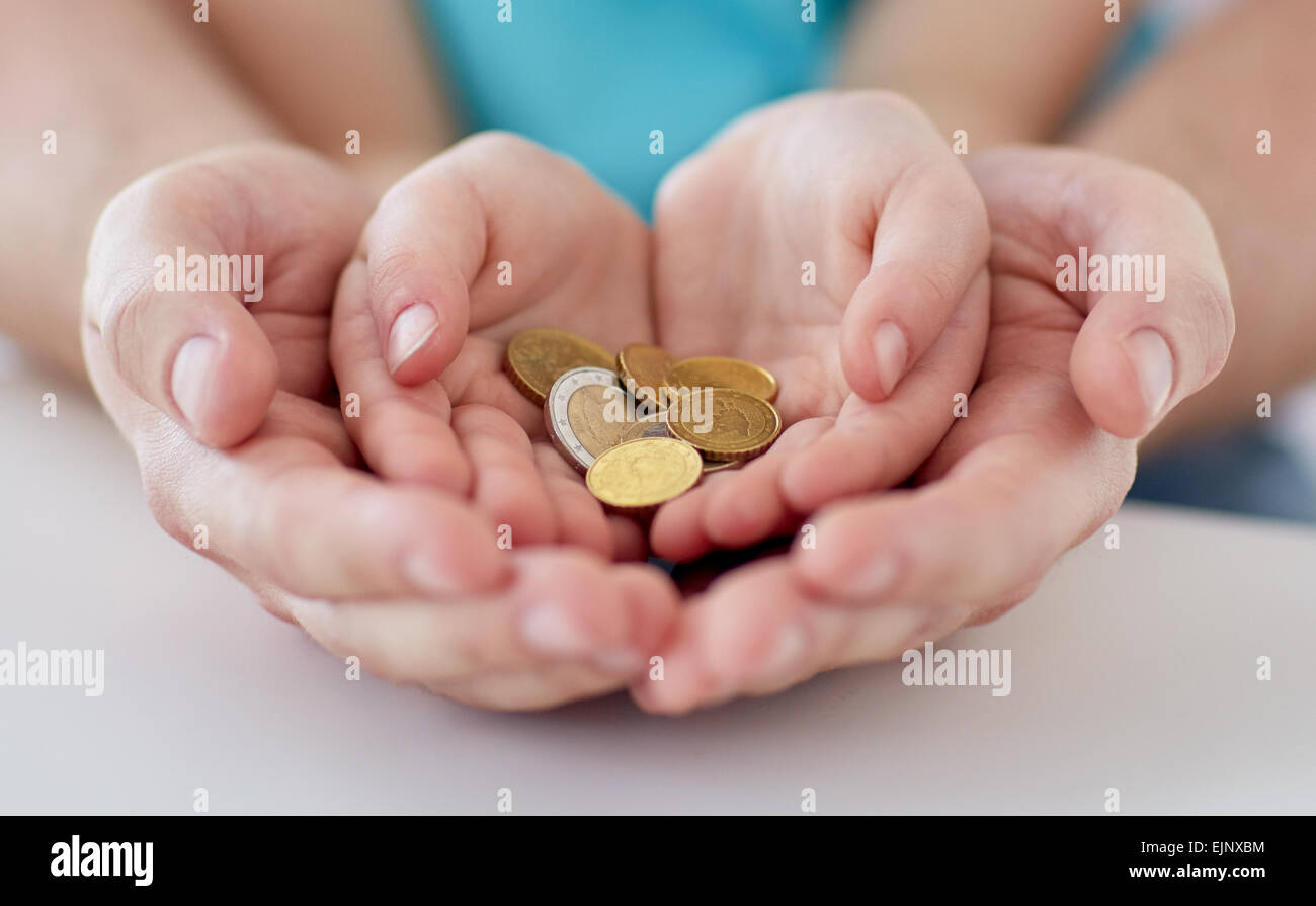 close up of family hands holding euro money coins Stock Photo