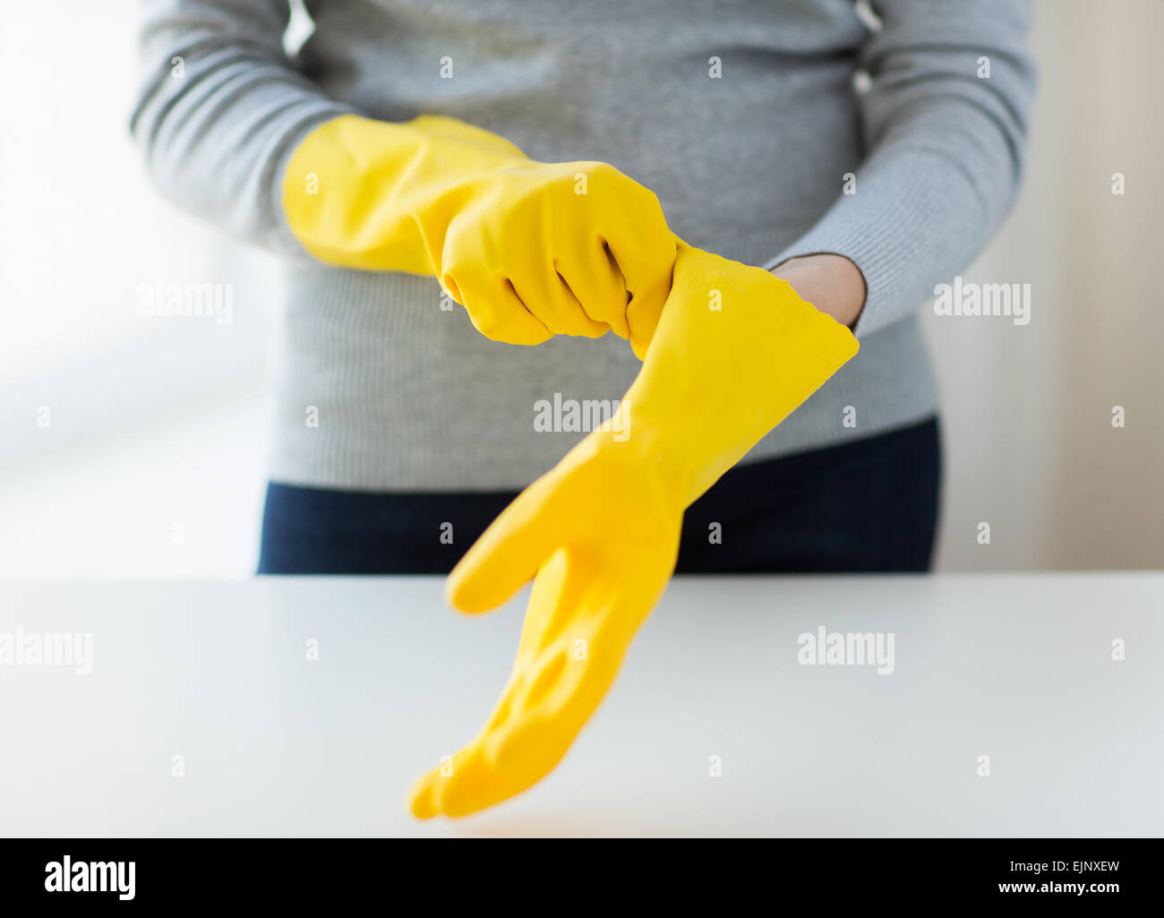 close up of woman wearing protective rubber gloves Stock Photo