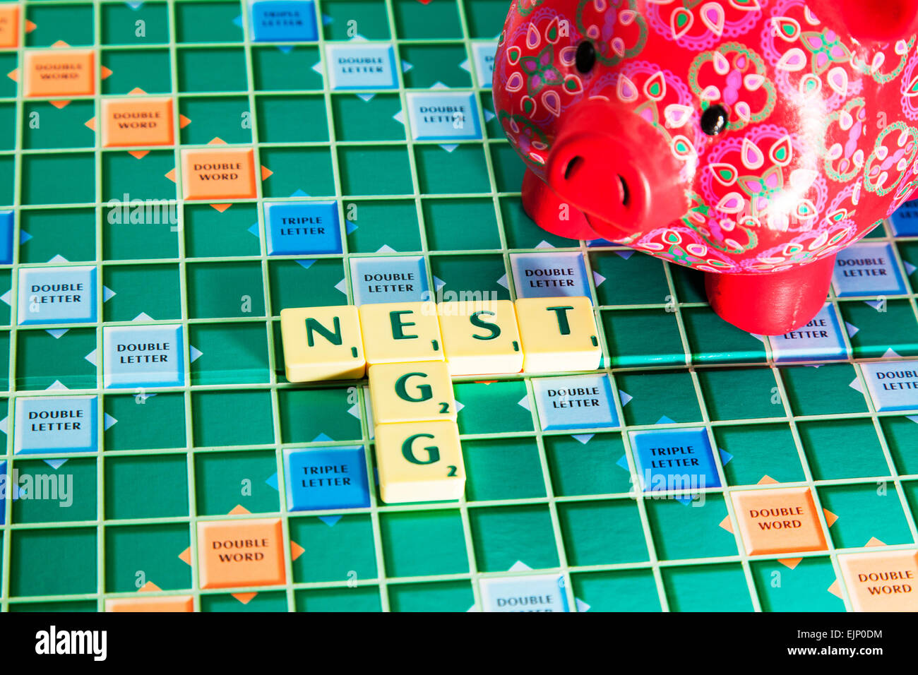 piggy bank nest egg savings money pound coins pension save rainy day words fund using scrabble tiles to illustrate spelling Stock Photo
