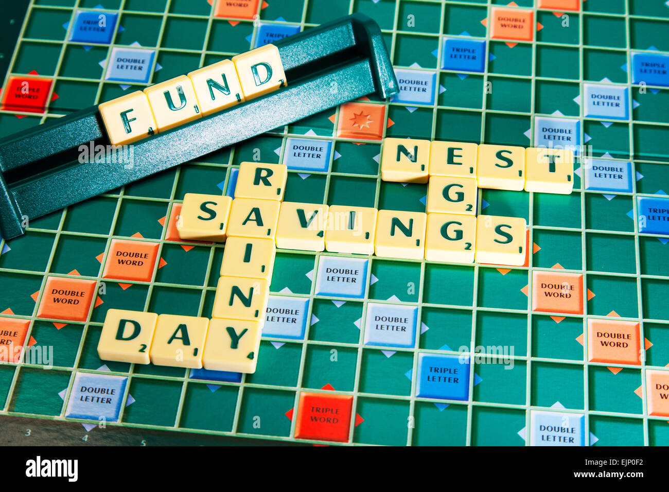 savings nest egg rainy day fund pension save future words using scrabble tiles to illustrate spelling spell out Stock Photo